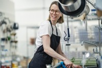 Eine Assistentin für Ernährung und Versorgung reinigt die Küche in einem Heim für Menschen mit Behinderungen.