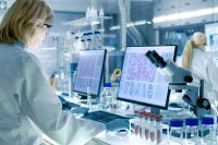 Eine Biologielaborantin mikroskopiert verschiedene Proben Blutzellen und wertet die Bilder am Computer aus.