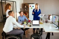 Eine Gruppe von vier Menschen versammeln sich um einen Tisch und besprechen eine Werbekampagne. 