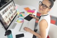 Eine gestaltungstechnische Assistentin feilt an dem Farbkonzept für den Social-Media-Auftritt eines Kunden.