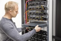 Ein Assistenten für Softwaretechnik erweitert die IT-Infrastruktur im Server-Raum.