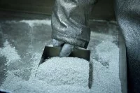 Ein Mitarbeiter eines Metallwerkes nimmt eine Probe von dem Silberpulver.