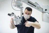 Ein technischer Assistent für medizinische Gerätetechnik wartet ein medizinisches Mikroskop.