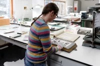 Eine Mitarbeiterin arbeitet in der Bildabteilung des Staatsarchivs Hamburg.