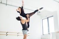 Eine Bühnentänzerin und ein Bühnentänzer proben ein Ballettstück ein.