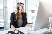 Eine kaufmännische Assistentin/ Wirtschaftsassistentin für Informationsverarbeitung führt ein Telefongespräch mit einem Kunden.