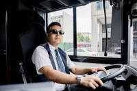 Eine Fachkraft im Fahrbetrieb steuert einen Bus der Berliner Verkehrsbetriebe durch die Berliner Innenstadt.