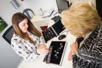 Eine Hörakustikerin berät eine Kundin über Hörgeräte.