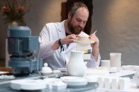 Ein Industriekeramiker arbeitet in der Besucherwerkstatt der Porzellan-Manufaktur Fürstenberg an einem Korb aus Porzellan.