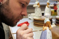 Ein Manufakturporzellanmaler bemalt die Kleidung der Porzellanfigur "Schokoladenmädchen" in der Staatlichen Porzellan-Manufaktur Meissen.