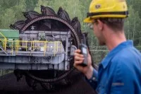 Ein Maschinen- und Anlagenführer steht auf einem Bandwagen im Tagebau Vereinigtes Schleenhain und überwacht die Fahrbewegung.