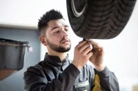 Ein Mechaniker für Reifen- und Vulkanisationstechnik überprüft das Profil eines Autoreifens.