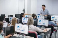 Lehrer und Auszubildende im Klassenzimmer mit PCs
