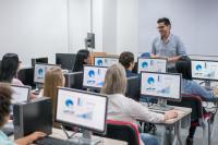 Lehrer und Auszubildende im Klassenzimmer mit PCs
