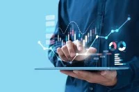 Ein Mensch mit Tablet in der Hand arbeitet an Statistiken.