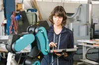 Azubi steuert Roboterarm