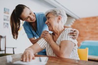 Pflegefachkraft umarmt ältere Patientin