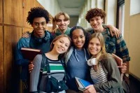 Eine Gruppe von sechs Jugendlichen in einer Schule, die in die Kamera lächeln.