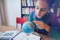 Junge Frau sucht auf dem Globus nach einem Land