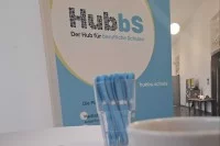 Der Stand von HubbS.schule auf dem Zukunftskongress mit Roll-Up, Kaffeetasse, Stiften und Flyern.