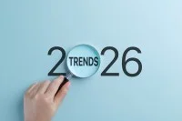 Eine Hand hält eine Lupe, die sich auf das Wort Trends innerhalb des Jahres 2026 konzentriert. 
