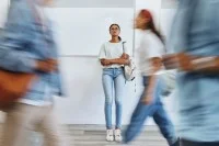 Junge Frau steht nachdenklich in einer Berufsschule