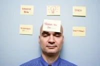 Mann hat geschlossene Augen und sechs gelbe Post-It um sich herum  