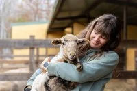 Bäuerin mit Lamm auf dem Arm