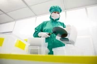 Eine Mikrotechnologin arbeitet mit Wafern im Reinraum am Fraunhofer-Institut für Mikroelektronische Schaltungen und Systeme.