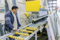 Ein Naturwerksteinmechaniker bearbeitet Marmor mit einer Maschine.