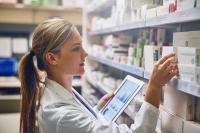 Eine Pharmazeutisch-kaufmännische Angestellte prüft den Medikamentenbestand in der Apotheke.