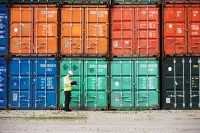 Ein Schifffahrtskaufmann sucht seinen Container mit zu verschiffenden Waren.