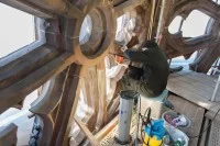 Eine Steinmetzin restauriert eine Strebe im Westturm vom Münster in Freiburg.
