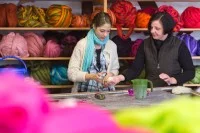 Zwei Textilgestalterinnen arbeiten in der Filzmanufaktur Retzow an farbigen Filzprodukten.