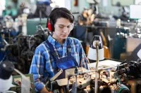 Eine Werkgehilfin Schmuckwarenindustrie, Taschen- und Armbanduhren verarbeitet Ersatzteile für eine Armbanduhr an einer Maschine.