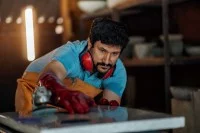 Ein Werksteinhersteller poliert eine Terrazzoplatte.