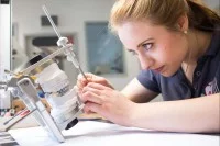 Damit die Zahnprothese später auch perfekt passt, simuliert eine Zahntechnikerin in einem Artikulator die Bewegungen des Kiefergelenks.