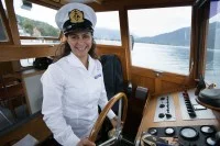 Eine Binnenschifffahrtskapitänin steuert die Fähre über den Tegernsee.