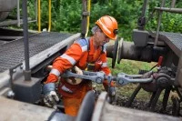 Ein Eisenbahner in der Zugverkehrssteuerung verbindet zwei Waggons miteinander.
