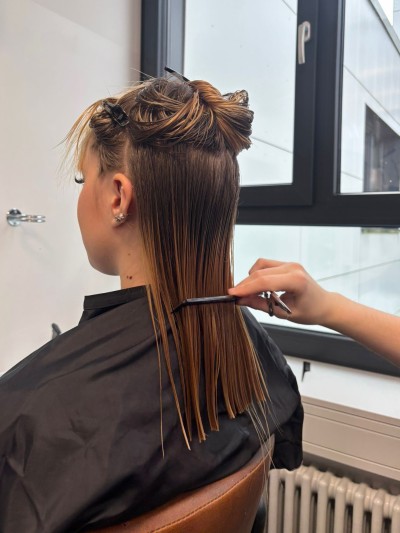 Ein Friseur-Azubi der Gewerblichen Schule Bad Mergentheim schneidet und stylt Haare. 