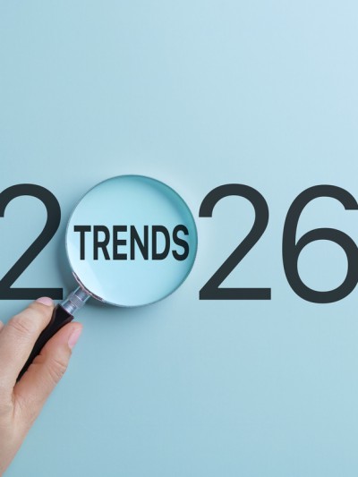 Eine Hand hält eine Lupe, die sich auf das Wort Trends innerhalb des Jahres 2026 konzentriert. 