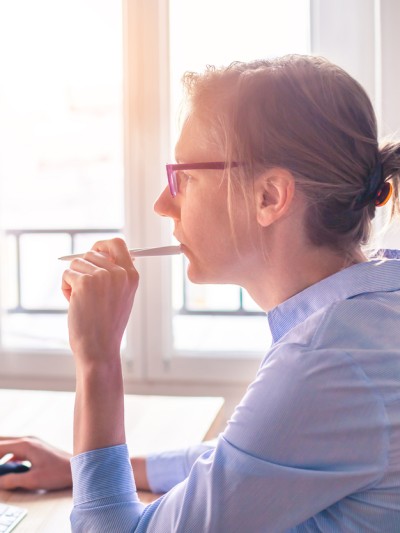 Eine Frau organisiert Termine, Aufgaben und Arbeitszeiten am Computer mit einem digitalen Kalender.