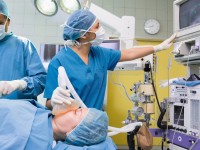 Eine anästhesietechnische Assistentin überwacht die Vitalfunktionen einer Patientin während der Operation.