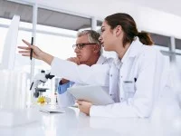 Eine medizinische Technologin für Veterinärmedizin und ein Fachtierarzt für klinische Laboratoriumsdiagnostik analysieren gemeinsam die Ergebnisse einer Blutuntersuchung am Computer.