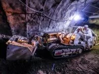 Mit dem Raupenbagger erschließen Berg- und Maschinenmänner Steinkohle in einem Bergwerk.
