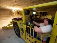 Eine Bergbautechnologin fährt im Werk Werra der K+S KALI GmbH einen Firstankerbohrwagen, der für die untertägige Gewinnung, Sicherung und Erkundung genutzt wird.