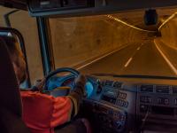 Ein Berufskraftfahrer fährt mit seinem Lastwagen durch einen Tunnel.