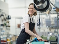 Eine Assistentin für Ernährung und Versorgung reinigt die Küche in einem Heim für Menschen mit Behinderungen.