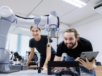 Eine technische Assistentin testet mit einem Techniker in einem Labor den Prototyp eines neuen Roboters.