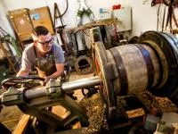 Ein Böttcher arbeitet an einer Ausdrehmaschine in einer Fassfabrik in München.